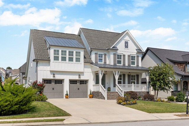 view of front facade with covered porch, a garage, and a front lawn