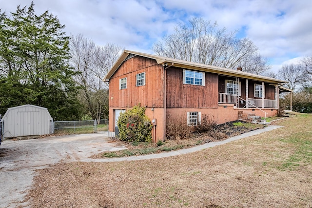 view of home's exterior featuring covered porch, a shed, and a garage