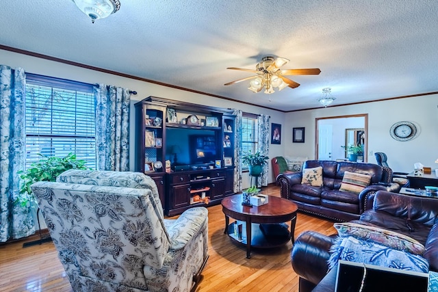 living room featuring a textured ceiling, ceiling fan, light hardwood / wood-style flooring, and ornamental molding