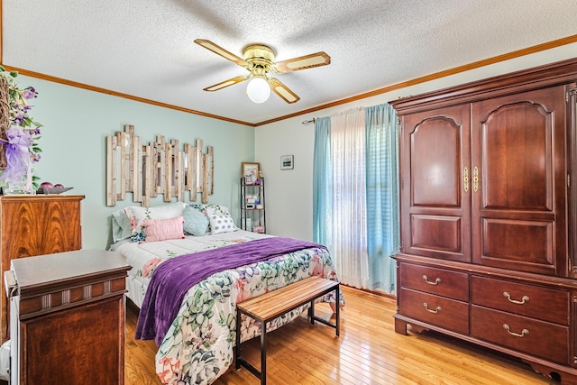 bedroom featuring ceiling fan, light hardwood / wood-style floors, ornamental molding, and a textured ceiling