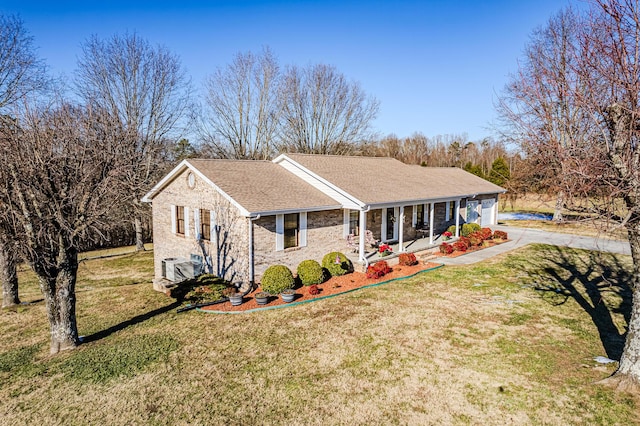 view of front of home featuring a porch, central AC, a front lawn, and a garage