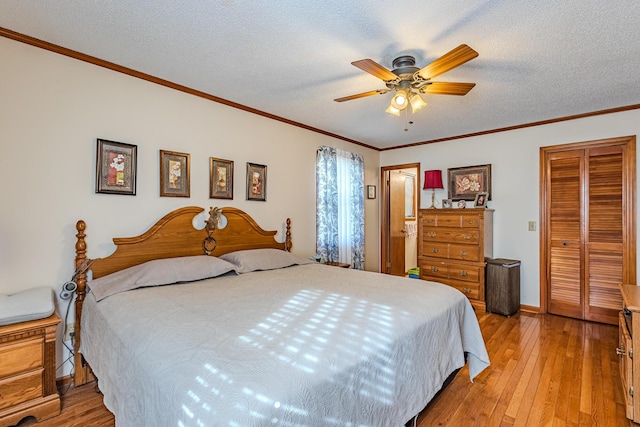 bedroom with a textured ceiling, hardwood / wood-style floors, ceiling fan, a closet, and crown molding