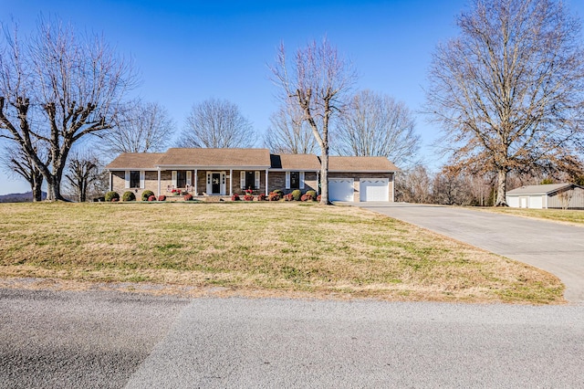 single story home with a front yard, covered porch, and a garage