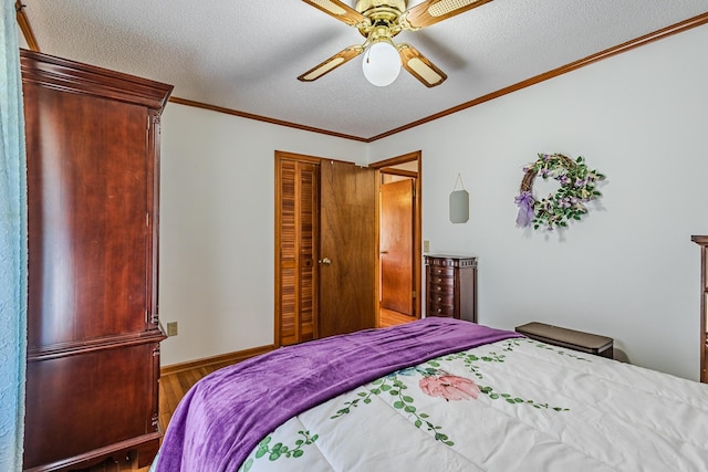 bedroom with ceiling fan, ornamental molding, a textured ceiling, and wood-type flooring