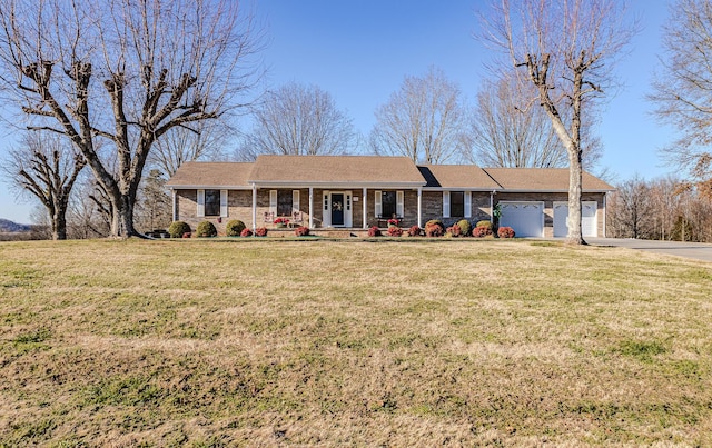 ranch-style house featuring covered porch, a front yard, and a garage