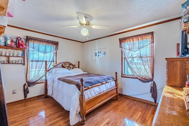 bedroom featuring a textured ceiling, ceiling fan, crown molding, and light hardwood / wood-style floors