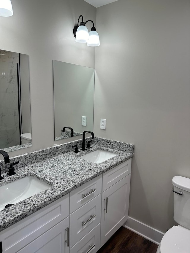 bathroom featuring hardwood / wood-style flooring, vanity, toilet, and walk in shower