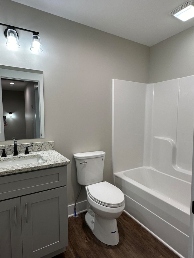 full bathroom with hardwood / wood-style flooring, vanity, toilet, and shower / bathing tub combination