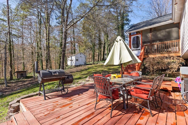 deck featuring a storage shed, outdoor dining space, an outdoor structure, and a grill