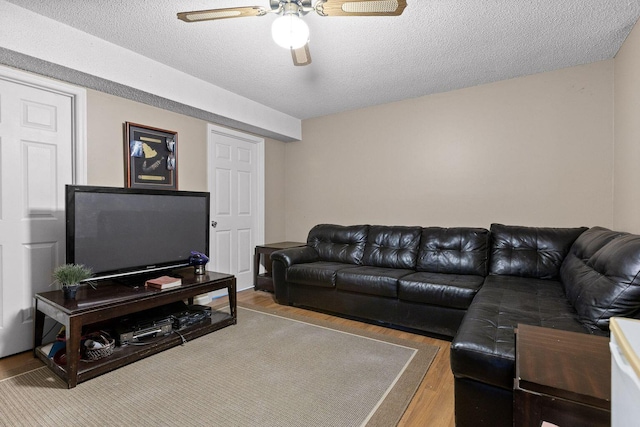 living room featuring a textured ceiling, a ceiling fan, and wood finished floors