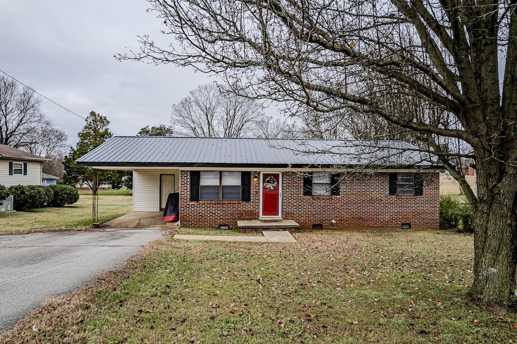 single story home featuring a front lawn and a carport