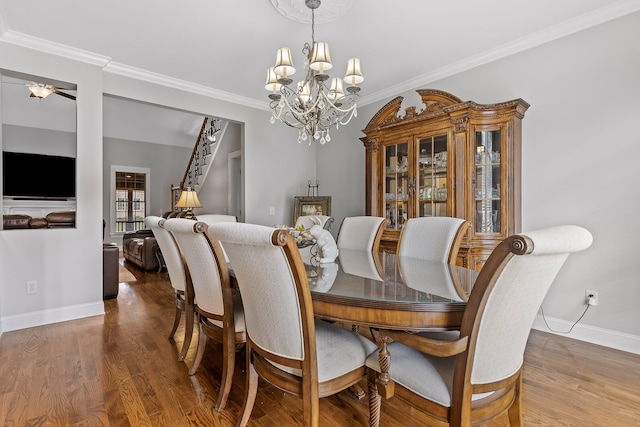 dining area with hardwood / wood-style floors, ceiling fan with notable chandelier, and ornamental molding