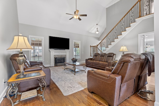 living room with ceiling fan with notable chandelier and hardwood / wood-style flooring