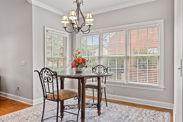 dining room with a chandelier, hardwood / wood-style flooring, crown molding, and a healthy amount of sunlight