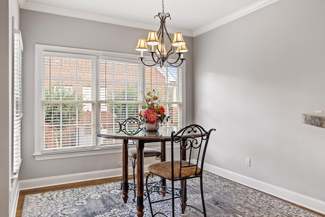 dining area with hardwood / wood-style floors, crown molding, and a chandelier