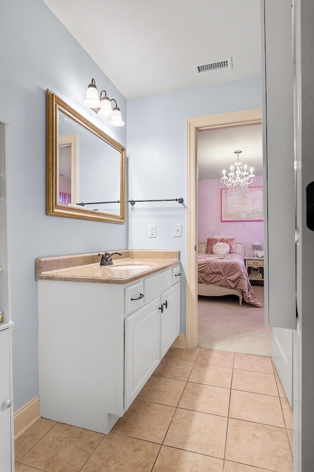 bathroom with tile patterned floors, vanity, and a notable chandelier