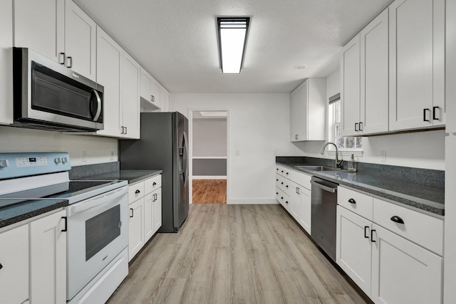 kitchen featuring sink, white cabinets, a textured ceiling, and appliances with stainless steel finishes