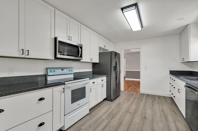 kitchen with white cabinets, stainless steel appliances, light hardwood / wood-style flooring, and a textured ceiling