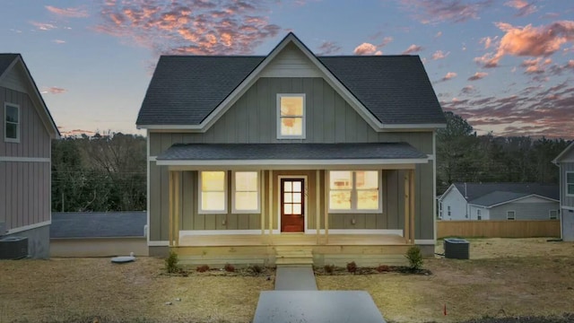 view of front of property with covered porch, a shingled roof, central AC, and board and batten siding