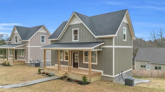 view of front of home featuring roof with shingles, a porch, board and batten siding, and cooling unit