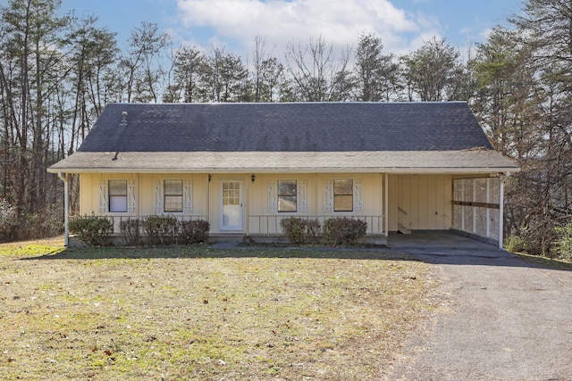 view of front of home with a front yard, a carport, and a porch