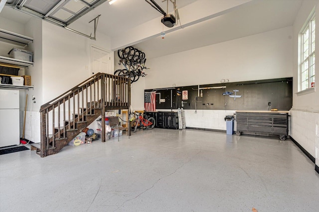 2074 Volunteer Dr SW, Cleveland, TN 37311 - garage featuring freestanding refrigerator, a workshop area, and a garage door opener