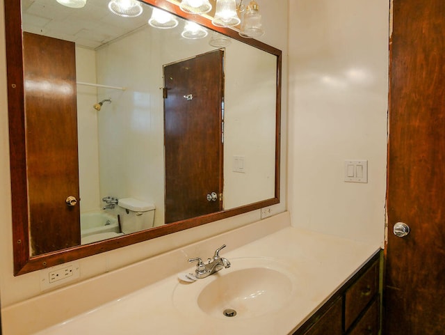 full bathroom featuring toilet, vanity, and tub / shower combination