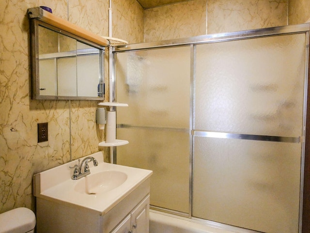 full bathroom featuring vanity, bath / shower combo with glass door, and toilet