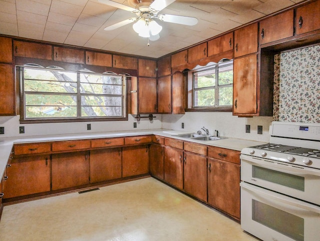 kitchen with a healthy amount of sunlight, ceiling fan, gas range gas stove, and sink