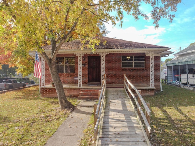 bungalow featuring a front lawn and a porch