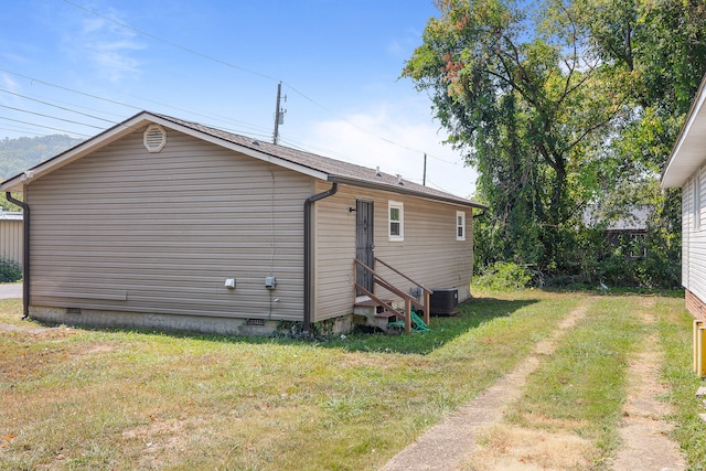 back of house featuring a lawn and central AC