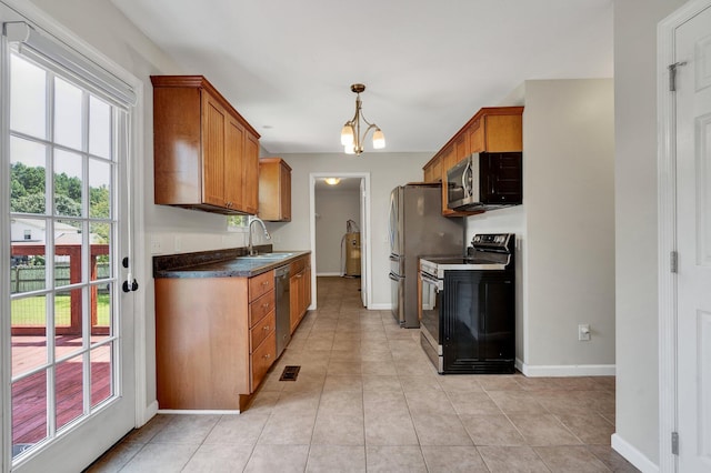 kitchen featuring sink, hanging light fixtures, stainless steel appliances, an inviting chandelier, and light tile patterned floors