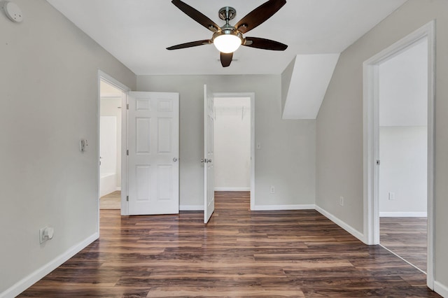 unfurnished bedroom with a closet, dark hardwood / wood-style floors, a spacious closet, and ceiling fan