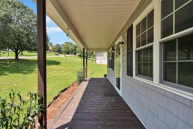 wooden terrace with a yard and a porch