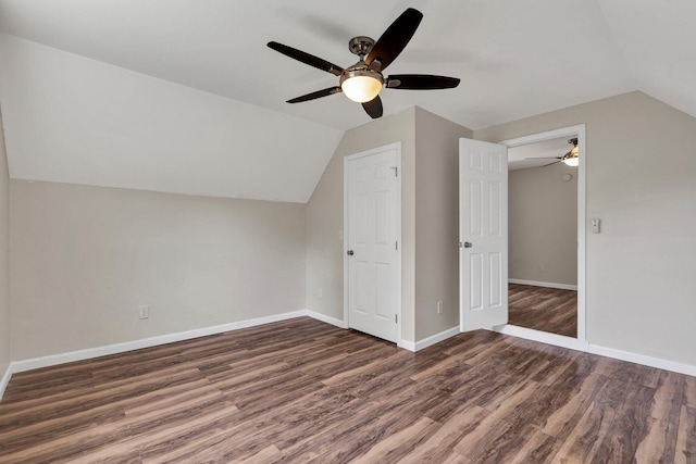 additional living space featuring dark hardwood / wood-style flooring, vaulted ceiling, and ceiling fan