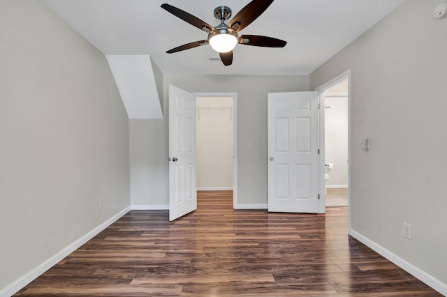 unfurnished bedroom featuring dark hardwood / wood-style flooring, a closet, a spacious closet, and ceiling fan