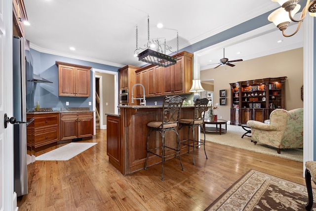 kitchen with light stone countertops, light wood-type flooring, and oven