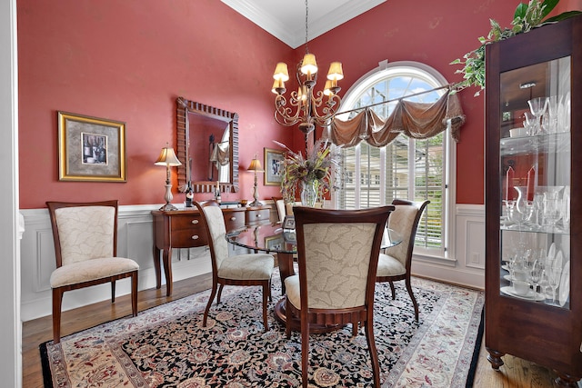 dining space featuring light hardwood / wood-style floors, a towering ceiling, crown molding, and a chandelier