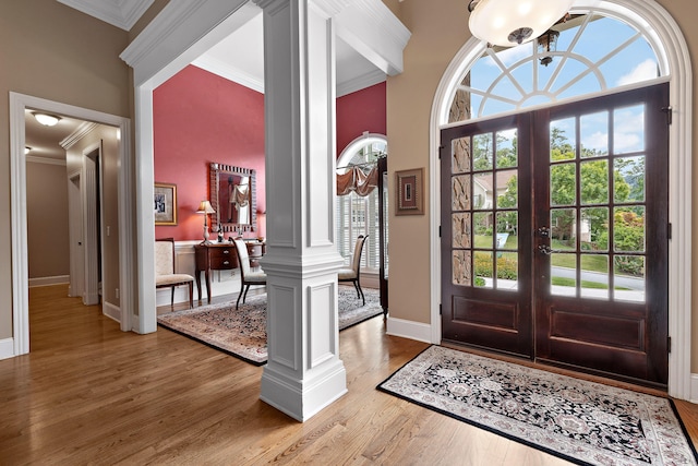 foyer with decorative columns, a wealth of natural light, french doors, and hardwood / wood-style flooring