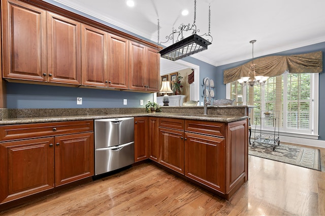 kitchen with kitchen peninsula, ornamental molding, light hardwood / wood-style floors, and an inviting chandelier