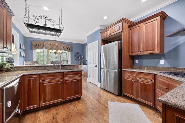 kitchen featuring appliances with stainless steel finishes, light wood-type flooring, crown molding, sink, and an inviting chandelier