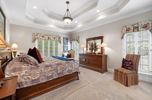 carpeted bedroom featuring a tray ceiling, multiple windows, and ornamental molding