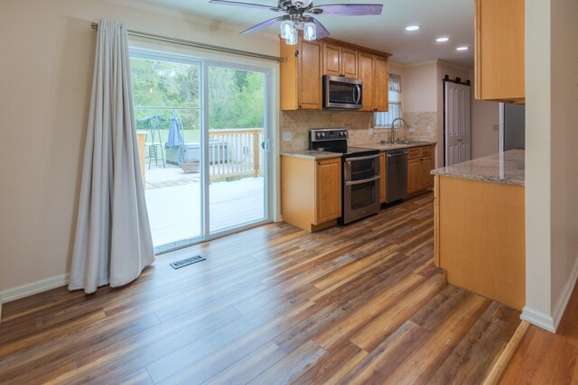 kitchen featuring backsplash, ornamental molding, dark wood-type flooring, and appliances with stainless steel finishes