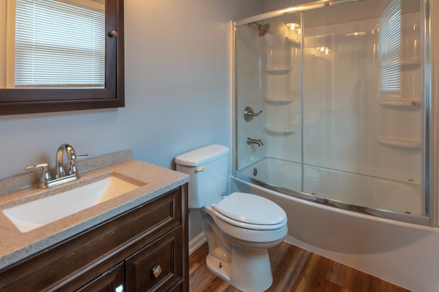 full bathroom with toilet, vanity, bath / shower combo with glass door, and hardwood / wood-style flooring