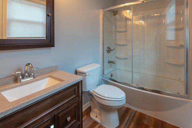 full bathroom with toilet, vanity, bath / shower combo with glass door, and hardwood / wood-style flooring