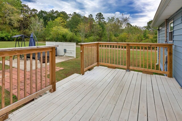 wooden terrace with a yard and a patio