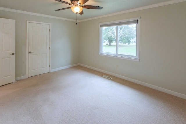 unfurnished bedroom with ceiling fan, crown molding, and light carpet