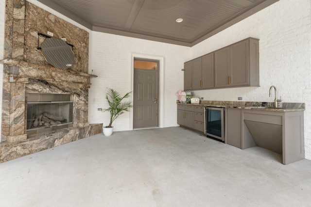 715 Pembridge Cir NW, Cleveland, TN 37312 - kitchen with wine cooler, gray cabinetry, concrete floors, and a stone fireplace