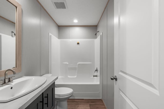 full bathroom featuring washtub / shower combination, wood-type flooring, vanity, and toilet