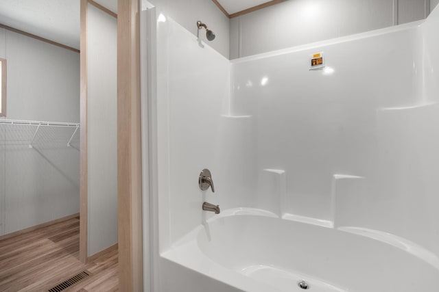 bathroom with hardwood / wood-style floors and tub / shower combination